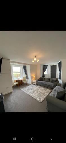 a living room with a couch and a table at Farina Holiday apartments in Bridlington