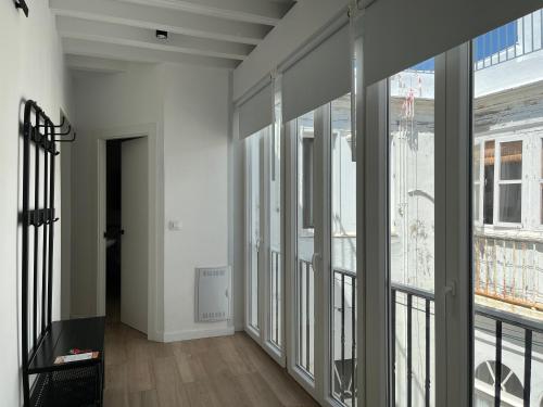 ein leeres Zimmer mit Glastüren und einem Balkon in der Unterkunft Plaza Libertad Grupo AC Gestion in Cádiz