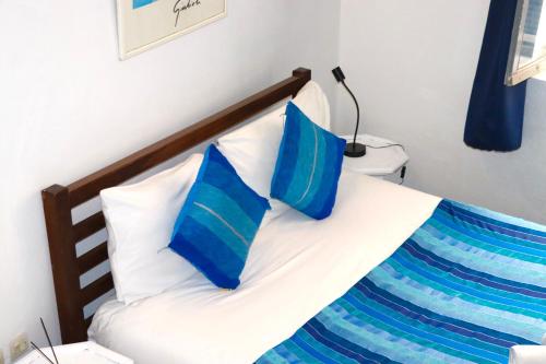 a bedroom with a bed with blue and white pillows at Riad Dar Latigeo in Essaouira