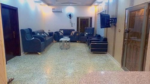a waiting room with blue chairs and a table at شقه مفروشه للايجار و بيت مزرعة مفروشه للايجار in Jerash