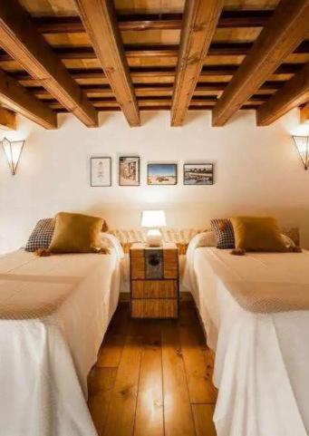 a room with two beds and a table with a lamp at La Posada de Juan in Cádiz