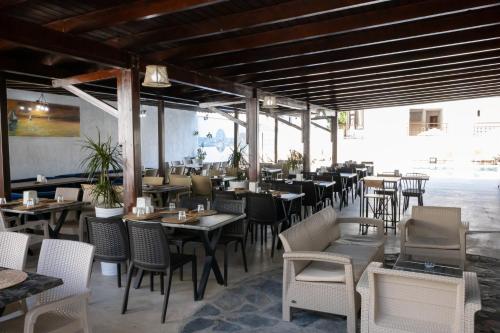 a restaurant with tables and chairs in a room at Salinas Hotel in Gümbet