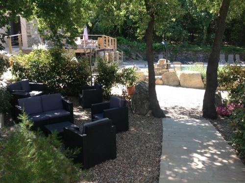 a row of black chairs in a garden with trees at Domaine Casa Andria in Barbaggio