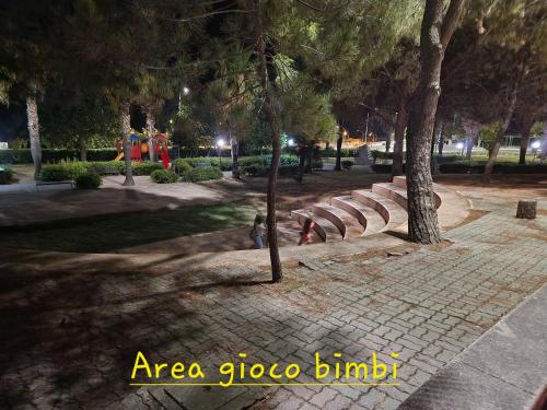 a park with a park bench and trees at night at Nina's house 5 a 300 mt dal mare in Santa Caterina Dello Ionio Marina