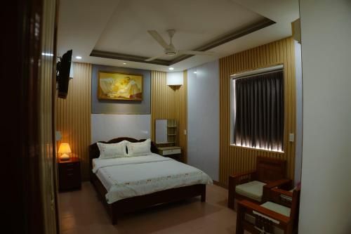 a bedroom with a large bed and a window at Hoàng Sơn Hotel in Ho Chi Minh City