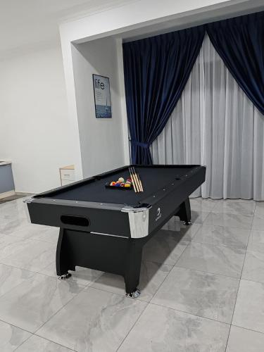 a black pool table sitting in a room with at Villa with private pool in Melaka