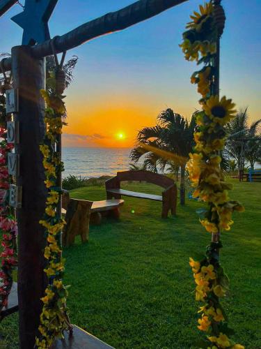 a view of a park with benches and a sunset at ASAS DEL MAR - SUITES in Canoa Quebrada