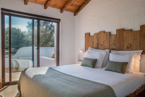 a bedroom with a large bed with a wooden headboard at Casa da Azeitona T1 - Monte do Serrado de Baixo in Évora