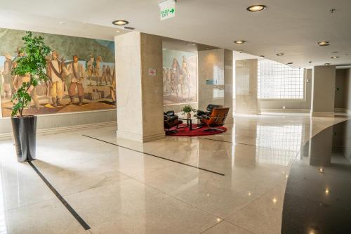 a lobby with a potted plant and paintings on the wall at Hotel Nacional Inn Jaragua Sao Paulo in Sao Paulo