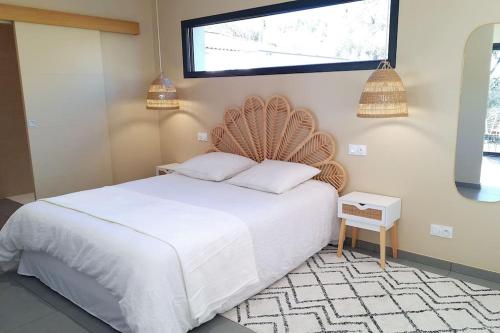 une chambre avec un lit blanc et une fenêtre dans l'établissement Dépendance studio cosy, à Cannes-et-Clairan