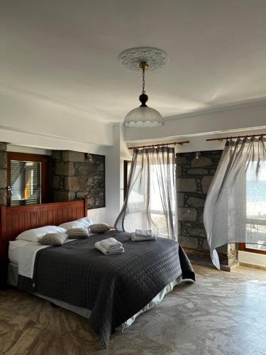 a bedroom with a large bed and a stone wall at Blue Waters in Mirina