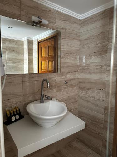 a bathroom with a white sink and a mirror at Leeon seaside in Myrina