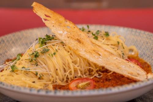 a bowl of spaghetti with a pair of utensils on it at Hotel Nacional Inn Jaragua Sao Paulo in Sao Paulo