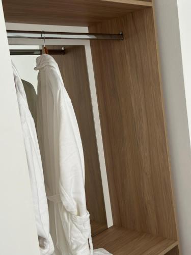 a closet with white shirts hanging on a rod at Riviera Hotel-City Center in Vlorë