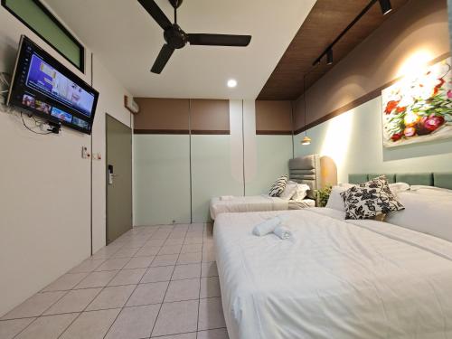 Un dormitorio con dos camas y un televisor de pantalla plana. en Kepayan Inn Kinabalu city, en Kota Kinabalu