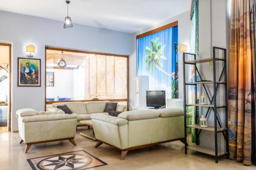 a living room with two couches and a television at Salinas Hotel in Gümbet