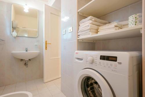 a white washing machine in a bathroom with a sink at Agriturismo La Genziana in Alghero