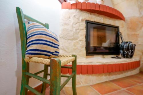 a pillow sitting on a chair in front of a stone fireplace at Agriturismo La Genziana in Alghero