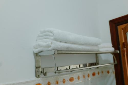 a stack of towels on a towel rack in a bathroom at Hoàng Sơn Hotel in Ho Chi Minh City