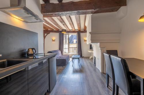 une cuisine avec un évier et une table avec des chaises dans l'établissement Logis de la Prévôté, à Saint-Aignan