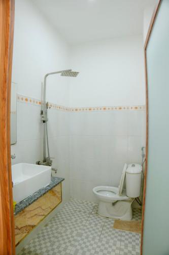 a bathroom with a toilet and a bath tub at Hoàng Sơn Hotel in Ho Chi Minh City