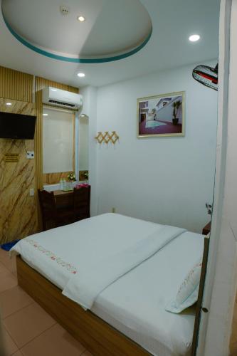 a bedroom with a large white bed in a room at Hoàng Sơn Hotel in Ho Chi Minh City