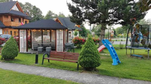 a park with a playground with a bench and a slide at Pokoje i Apartament U Ireny in Poronin