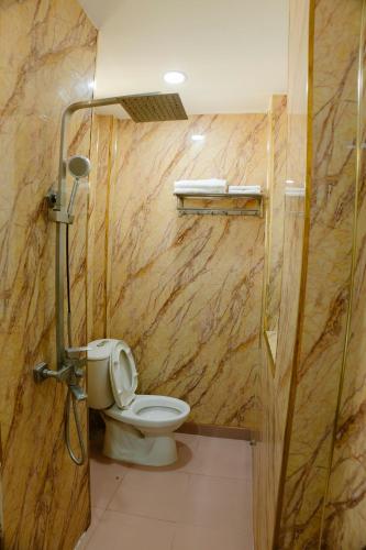 a bathroom with a toilet and a wooden wall at Hoàng Sơn Hotel in Ho Chi Minh City