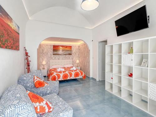 a bedroom with a bed and a television in it at Amalfi Rooms Duoglio Beach -amazing seaview in Amalfi