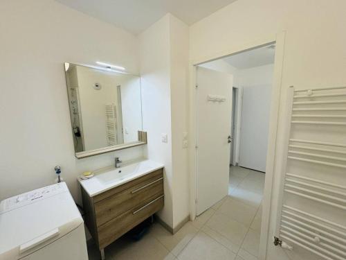 une salle de bain blanche avec un lavabo et un miroir dans l'établissement 3 pièces 68m², jardin clos, 150m plage, wifi, à Saint-Pierre-Quiberon