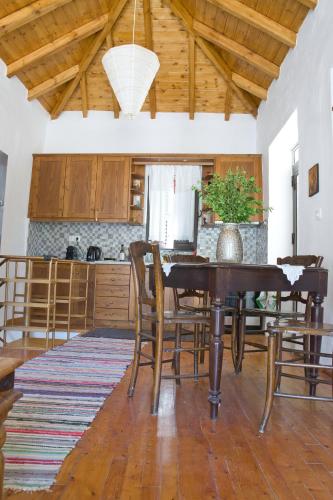 a kitchen with a dining room table and chairs at Velanidia Homestay in Velanídhia