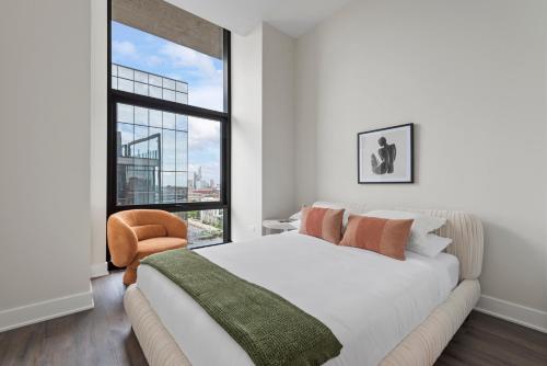 a bedroom with a bed and a large window at Avra Stylish Apartments Prime West Loop Location Near Union Park in Chicago