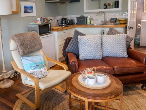 a living room with a couch and a table at The Apartment at Queen Anne's Lodge in Lyme Regis