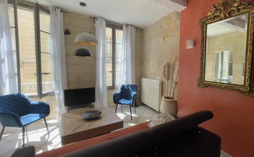 salon z kanapą i lustrem w obiekcie Le Cherche Midi - Appartement centre historique d'Uzès w mieście Uzès