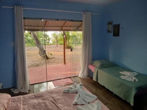 a bedroom with a bed and a sliding glass door at Pousada Grão in Belém