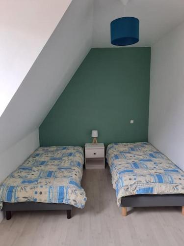 - 2 lits dans une chambre dotée d'un mur vert dans l'établissement Charmant T3 lumineux à 2 pas des plages Appart 5, à Binic