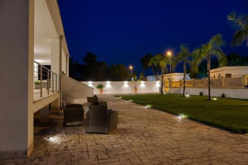 a patio with chairs and a lawn at night at Dimore Relais - Suite Garden Breakfast in Porto Cesareo