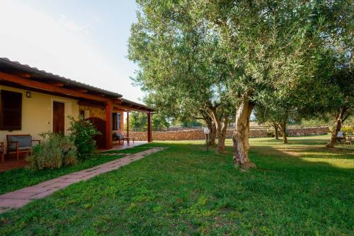 a house with a tree in the yard at Agriturismo La Genziana in Alghero