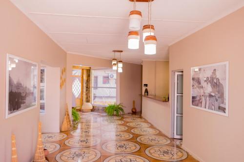 a hallway with a tile floor and a room with a kitchen at Hotel Prestige Ongwediva in Ongwediva