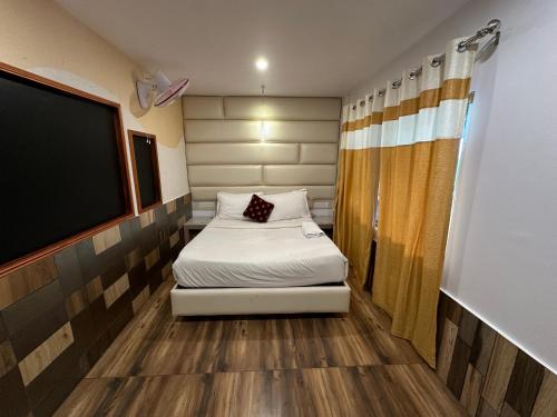 a small room with a bed and a flat screen tv at Parakkat Nature Resort in Munnar