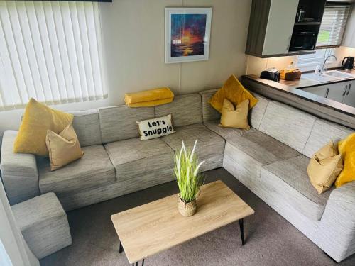 a living room with a couch and a table at Marigold lodge 8 at Oakdene Forest Park in Saint Leonards