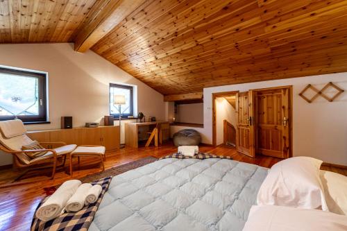 a large bed in a room with a wooden ceiling at MAISON MOULIN - Relax e vista Montagna - LA THUILE 0107 in La Thuile