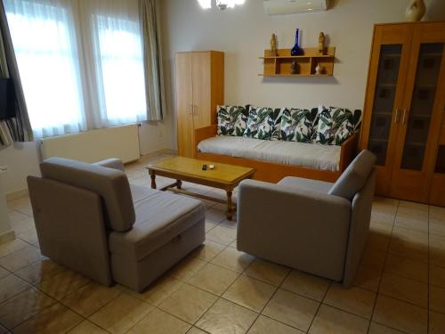 a living room with two chairs and a couch at Alabárdos Panzió és Apartmanház in Esztergom