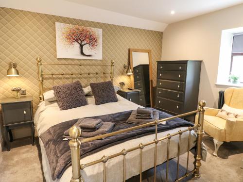 a bedroom with a bed and a chair at Dale End Farm Cottage in Bakewell