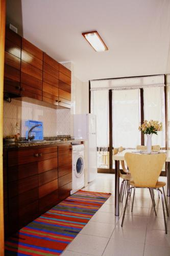 a kitchen with a table and a white refrigerator at Flat Accommodation in Braga in Braga