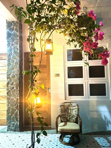 a chair sitting in front of a door with flowers at Balay na Bato in Legazpi