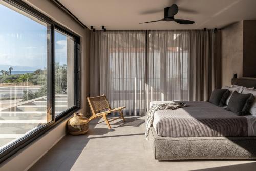 a bedroom with a bed and a large window at Nikoleta Hotel and Villas in Limenas