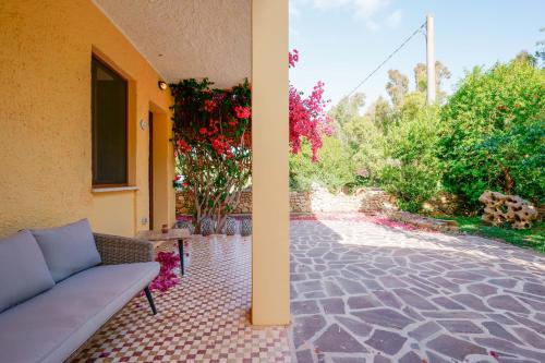 a couch sitting on a patio next to a building at Agriturismo La Genziana in Alghero
