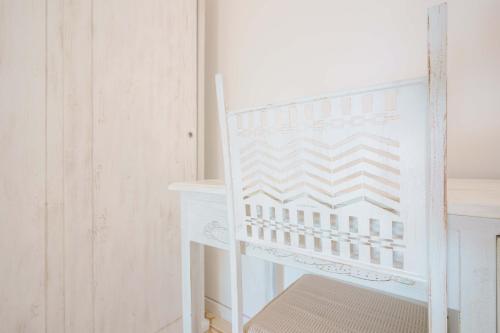 a white chair sitting next to a desk at Agriturismo La Genziana in Alghero