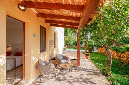 a patio with a bed and a table and chairs at Agriturismo La Genziana in Alghero